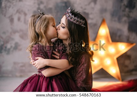 mother and daughter in the image of the queen and princess dresses in the colors of Marsala with a long train in the loft