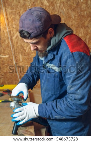 Man carpenter in repairing their working tools in his workshop