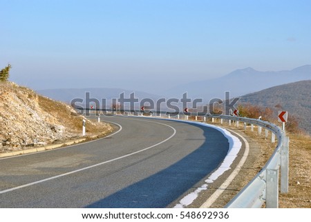 Empty asphalt road in the mountain on sunny winter day.