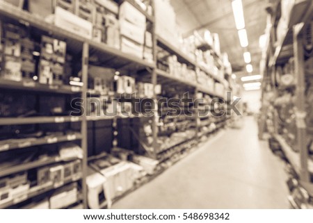 Blurred large hardware store in America. Defocused interior home improvement retailer with rack, aisle of signs, mailboxes, wet/dry vacuums, attic stairs, ladders and building materials. Vintage tone