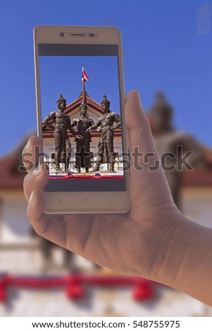 People use mobile phone photograph Three Kings Monument in Chiang mai
