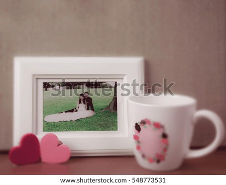 a wedding picture in white frame with hearts for valentine background, filtered tones