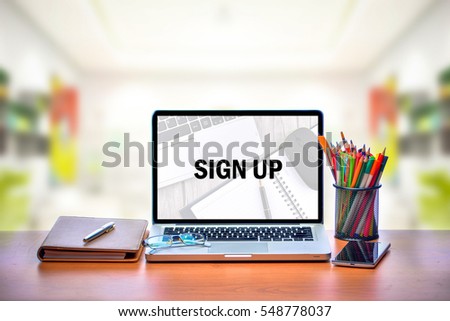Open laptop with isolated white screen on old wooden desk with text SIGN UP