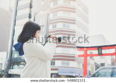 Beautiful Asian girl with camera taking pictures in city,tokyo japan