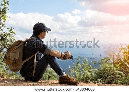 Man Traveler with photo camera and backpack hiking outdoor Travel Lifestyle and Adventure concept.
