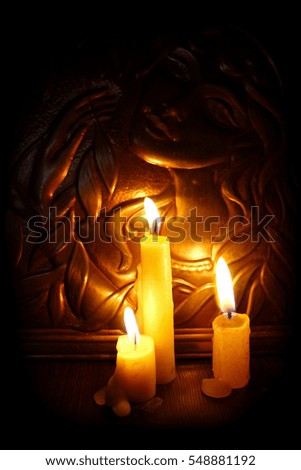 Candles burning in darkness on a background girl image