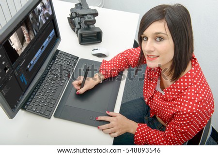young brunette female designer using graphics tablet for video editing