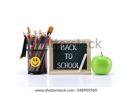 green chalkboard with stationery and a apple on white background