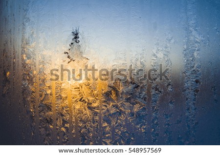 Beautiful winter frost patterns on the window at sunset