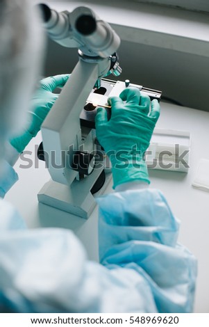 Close up crop view of scientist hands putting microscope glasses in special store box.