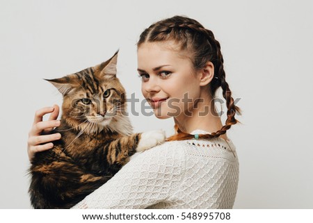 Woman with a cat in his hands looking at the camera. Maine Coon Cat