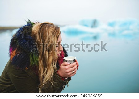 woman holding cup of coffee in Iceland