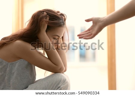 Someone giving hand to depressed woman at home Royalty-Free Stock Photo #549090334