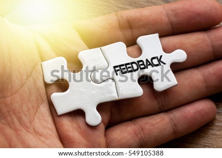 FEEDBACK written on White color of jigsaw puzzle with hand,conceptual