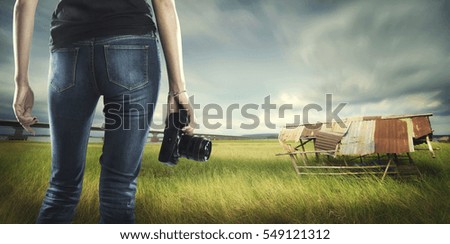 Photographer hold camera with landscape background.