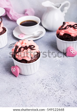 Beautiful chocolate cupcake, pink cream and heart on gray stone background. Valentines, Mother Day, wedding concept with with copy space.