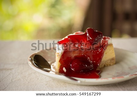 The picture of yummy fresh strawberry cheese cake serve in the white ceramic plate.