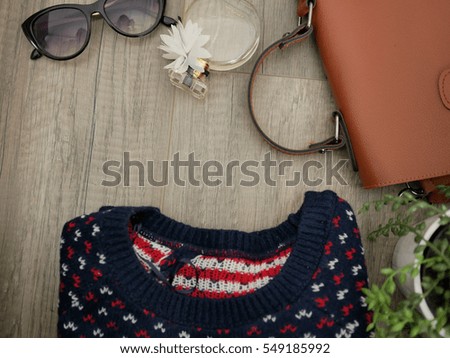 Flat lay of winter cloth and accessory on wooden table with copy space