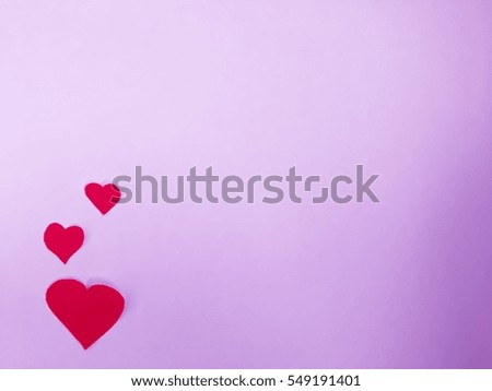 Three red paper heart on pink background
