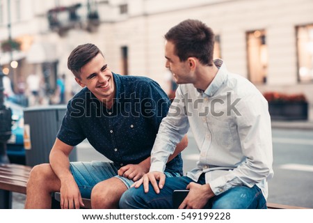 Friends talking together on a bench in the city Royalty-Free Stock Photo #549199228