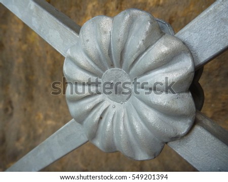 a decorative metal flower detail on a railing