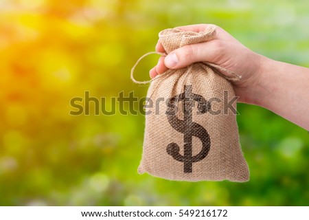 A businessman hand giving a bag from sacking with dollar sign