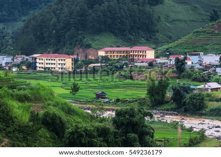 City among of mountains with yellow building and rice terraces, giant river in front