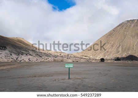 Green sign with message in Indonesia language "Banned
Approaching the tool seismograph" at desert- Bromo mountain - Indonesia