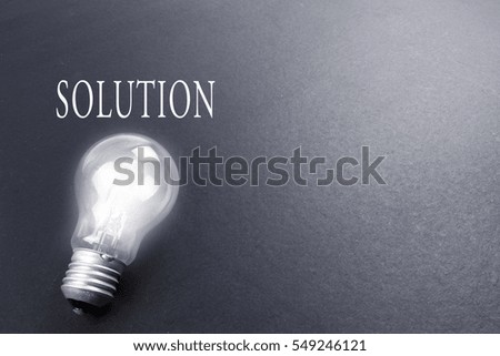 Idea concept word IDEA. Light of bulb on black background. Idea concept word solution. Low light