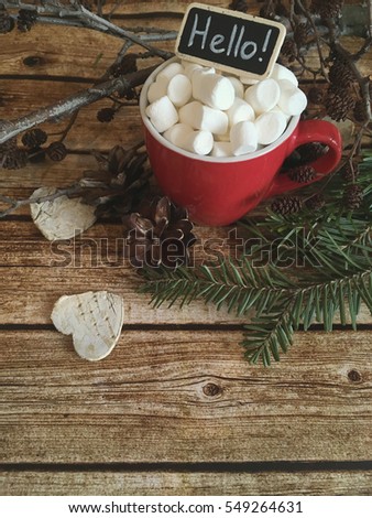 Valentines hello chalkboard. Red cup with marshmallows and white cedar on wooden background. Hello winter. Morning coffee