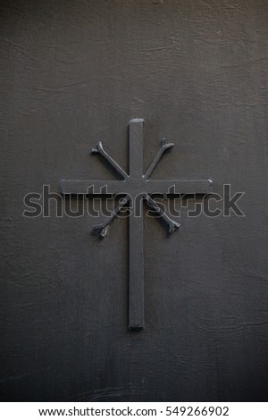 christian cross embossed on a black metal plate