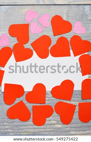 set of valentine red pink hearts with white paper sheet on grey vintage wooden background, copy space