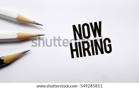 Now hiring memo written on a white background with pencils