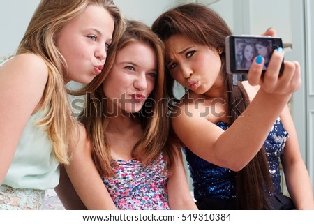 Teenage girls taking a picture of themselves making faces