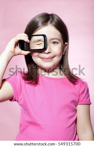 Girl holding smartphone over eye