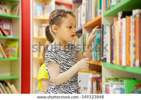  preschooler choosing books at   library.
