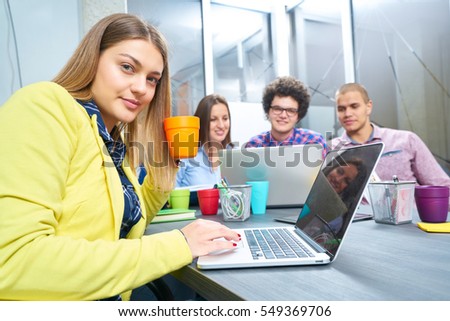 Portrait of startup group of creative people having a meeting with a laptop in a modern office. Business people having relaxed conversation over new project in coworking space