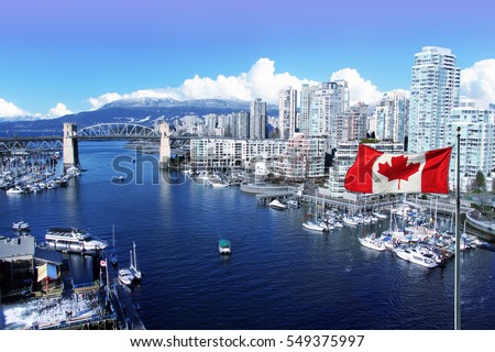 Canadian flag in front of view of False Creek and the Burrard street bridge in Vancouver, Canada.  Royalty-Free Stock Photo #549375997