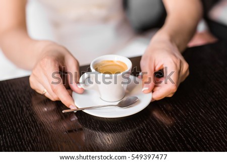 woman holding hot cup of coffee