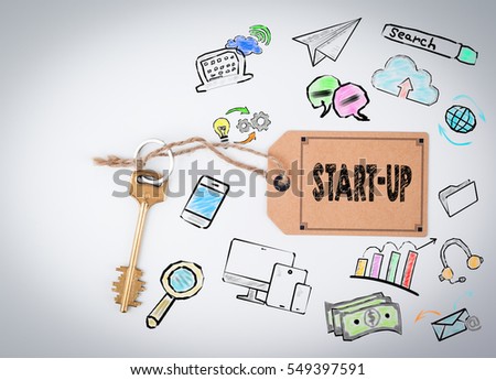 Start Up. Key and a note on a white background 