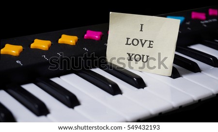 Black and white piano keys, words on paper sticker i love you