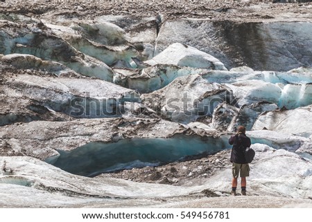 Man photographing glacier. Photographer in mountains