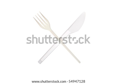 Plastic plug and knife lie a cross on a white background. Tablewares