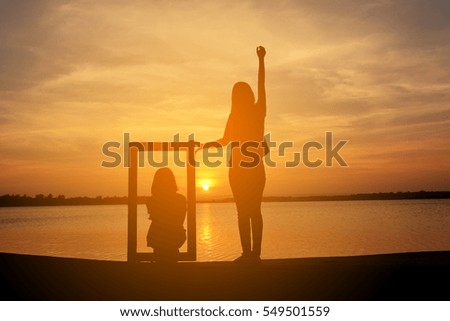 Silhouette of women holding frame at the sky sunset concept valentine day