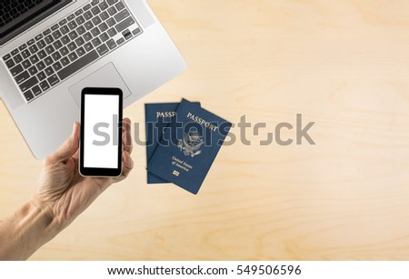 Hand holding smartphone with blank screen over desk