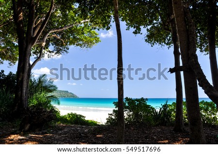 Stunning view of Radhanagar Beach on Havelock Island with trees and bushes in the foreground. Havelock Island is a beautiful small island belonging to the Andaman & Nicobar Islands in India, Asia.