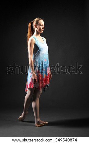 ballerina in a simple dress on a black background