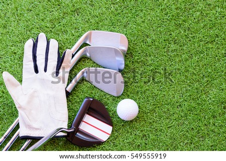 Equipment for playing golf on green grass background.