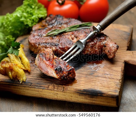 grilled juicy steak with rosemary.  Royalty-Free Stock Photo #549560176
