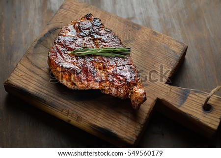 grilled juicy steak with rosemary. top view Royalty-Free Stock Photo #549560179